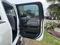 A 2016 GMC Sierra 1500 truck door is open showing the interior handle and armrest in black and gray materials