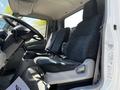Interior view of a 2020 Hino 155 showing two fabric seats with black and grey patterns and a steering wheel in the foreground