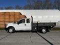 A white 2011 Ford F-350 SD with a flatbed truck design featuring a cab for three passengers and a side tool compartment