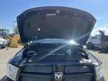 A 2011 RAM 1500 with its hood raised showing the engine compartment and various mechanical components inside