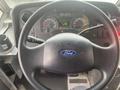 Steering wheel of a 2012 Ford Econoline featuring a Ford emblem along with dashboard gauges and controls in view