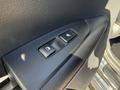 Close-up of the control panel on the door of a 2024 Kia Forte5 featuring window controls and a seat heater button