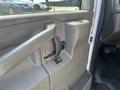 Interior door handle and controls of a 2016 GMC Savana with a simple gray design and a button for window operation