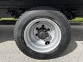 Close-up of a silver and black tire mounted on a dark truck rim showcasing the wheel's intricate design and tread pattern