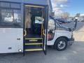 A 2018 Chevrolet Express bus with an open door revealing steps leading inside and a driver's seat visible in the foreground