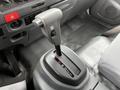 The gear shift lever of a 2022 Isuzu NPR with a black and silver design and a button on the side for gear selection