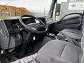 Interior view of a 2022 Isuzu NPR featuring a steering wheel dashboard and grey upholstery on the driver's seat and passenger seat