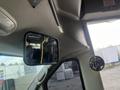 Interior view of a 2012 Chevrolet Express showing the driver side rearview mirror and a partial reflection of the driver in the cab