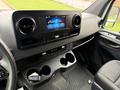 The interior of a 2019 Mercedes-Benz Sprinter featuring a modern dashboard with a touchscreen display and multiple cup holders