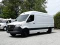 A 2023 Mercedes-Benz Sprinter van in white with a black lower section and no visible branding parked in a lot
