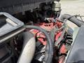 A close-up view of the engine compartment of a 2022 International MV607 showing various components including hoses wires and a red engine block