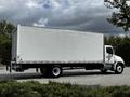A 2020 Hino 338 truck with a white box cargo area and visible wheels is parked on a road