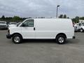 A white 2013 Chevrolet Express van parked sideways with a plain exterior and chrome wheels