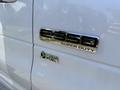 A white 2013 Ford Econoline E350 Super Duty van featuring a fuel badge