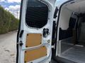The interior of a 2016 Ford Transit Connect with open rear doors showing a panel and security screen with a locking mechanism and the cargo space visible