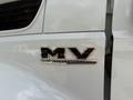 A chrome emblem featuring the letters MV and the word International on a white truck's door