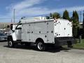A white 2009 GMC C5500 service truck with multiple compartments and a flatbed on the back