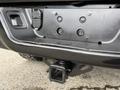 A 2018 RAM 1500 truck's rear end featuring the trailer hitch attachment point and wiring harness connectors
