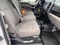 Interior view of a 2018 Ford F-150 showing front seats in gray upholstery and dashboard with various controls and a gear shift