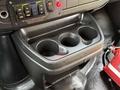 A black cup holder with three circular openings designed for holding drinks in the center console of a 2020 Chevrolet Express
