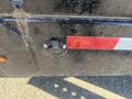 Close-up of a 2024 Southland 18 Foot Dump Trailer showing a black electrical plug and a red reflective strip on the side