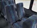 Interior seating of a 2020 Chevrolet Express with gray fabric and blue wave patterns featuring seatbelts on each chair