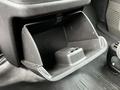 The interior of a 2023 GMC Savana showing an open glove compartment with a small storage area and a black box inside