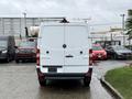 A white 2017 Mercedes-Benz Sprinter van viewed from the rear with its doors closed and a ladder rack mounted on top