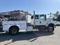 2007 International 7300 truck with a utility body featuring multiple storage compartments and equipment mounted on the back