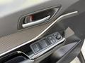 A 2021 Toyota C-HR driver door panel featuring a handle and control buttons for windows and locks