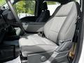 A driver's side seat of a 2024 Ford F-550 featuring gray fabric upholstery and a sleek design with adjustable settings
