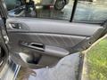 A 2021 Subaru WRX door interior featuring a sleek design with black leather-like material red stitching and a handle near the armrest