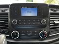 A 2022 Ford Transit dashboard featuring a touchscreen display with time and media controls including volume and climate settings