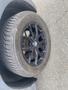 A black alloy wheel from a 2009 BMW X5 with a visible BMW logo and a tire with detailed tread patterns