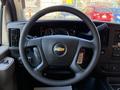 Steering wheel of a 2024 Chevrolet Express with control buttons and a logo in the center