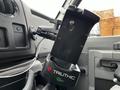 A black phone mount attached to the dashboard of a 2009 Ford Econoline with a wire visible connecting to the mount