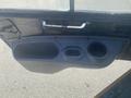 A close-up view of the interior door panel of a 2010 Trackless MT6 featuring a storage compartment and cup holder