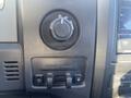 Close-up of the control panel in a 2013 Ford F-150 featuring a four-wheel drive selector and trailer brake controls