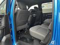 Interior view of the backseat of a 2021 RAM 1500 Classic featuring two rows of seats with a center armrest and floor mats