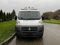 A 2018 RAM Promaster van facing forward with a white body and black lower front panel its roof has equipment mounted on it