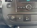 Interior dashboard controls of a 2014 GMC Savana including buttons for audio and vehicle settings with a circular dial in the center