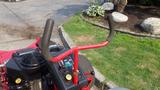 Close-up of the handle controls on a 2014 Ferris Zero-Turn mower with a red frame and black engine components