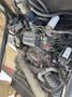 A view of the engine compartment of a 2015 Global Street Sweeper with various hoses wires and components visible