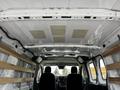 Interior view of a 2023 Ford Transit van showing a spacious cargo area with wooden support beams and two front seats visible