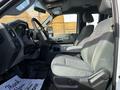 Interior of a 2011 Ford F-450 SD featuring two gray front seats with a center console visible between them and a dashboard with various controls and gauges