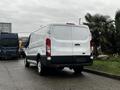 A white 2016 Ford Transit van parked with its rear view visible showing the license plate area and rear lights