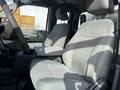 Interior of a 2011 Ford F-450 SD showing two gray upholstered front seats and a center console