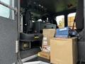 The interior of a 2009 Spartan Gladiator featuring black seats and various boxes stacked on the floor including automotive parts and equipment