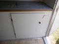 A white door with a knob and a keyhole on a small trailer interior with a countertop above it