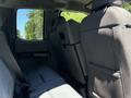 Interior view of the rear seating area of a 2020 Ford F-350 SD featuring gray upholstery and a fold-down armrest
